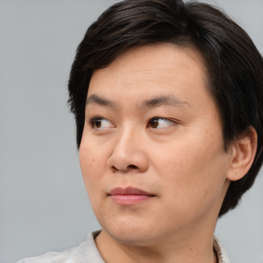 Joyful asian adult male with medium  brown hair and brown eyes
