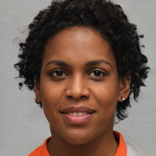 Joyful black young-adult female with short  black hair and brown eyes