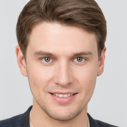 Joyful white young-adult male with short  brown hair and grey eyes