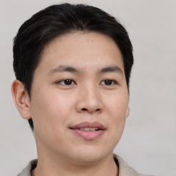 Joyful asian young-adult male with short  brown hair and brown eyes