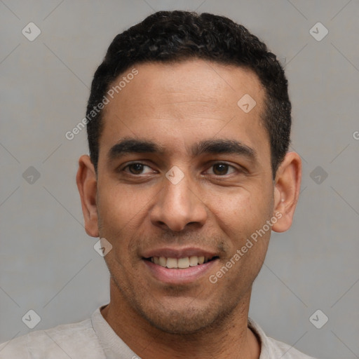 Joyful latino young-adult male with short  black hair and brown eyes