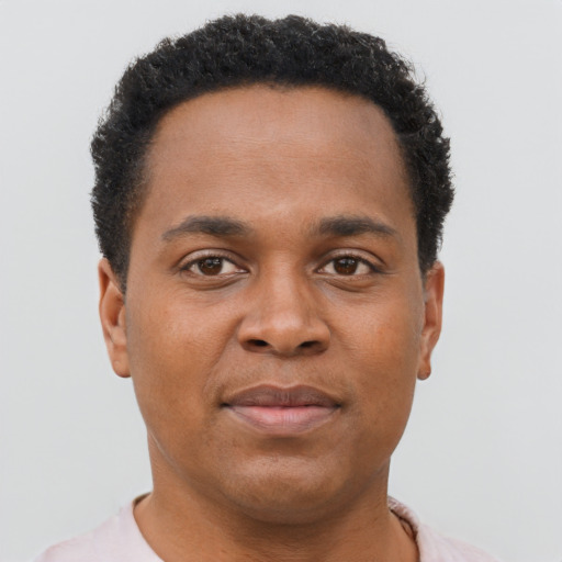 Joyful black young-adult male with short  brown hair and brown eyes