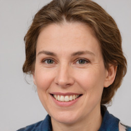 Joyful white adult female with medium  brown hair and grey eyes