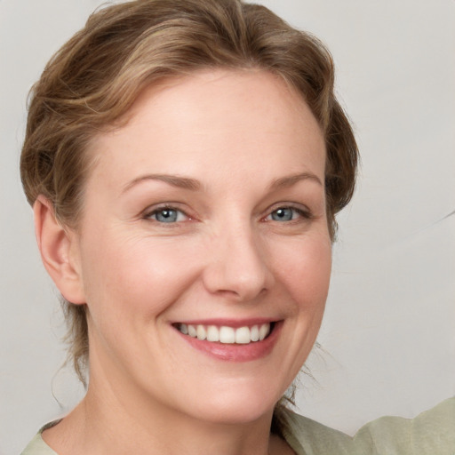 Joyful white young-adult female with medium  brown hair and grey eyes