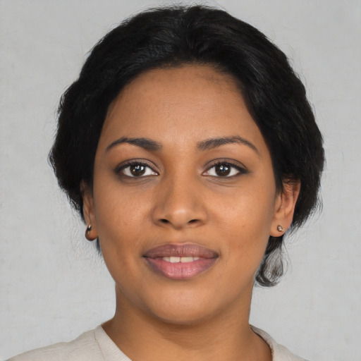 Joyful black young-adult female with medium  black hair and brown eyes