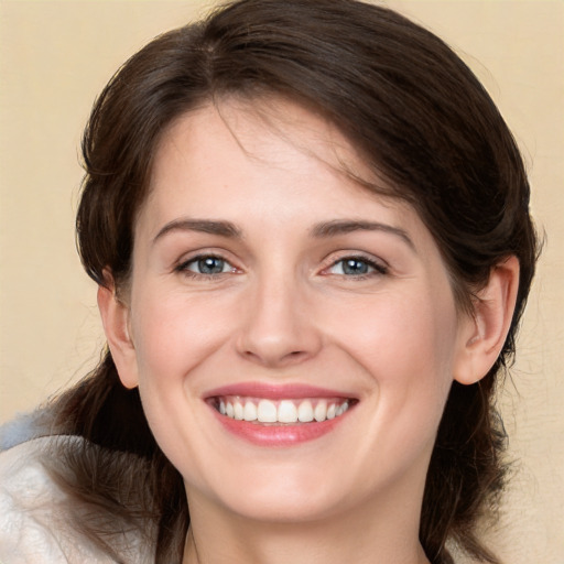 Joyful white young-adult female with medium  brown hair and grey eyes