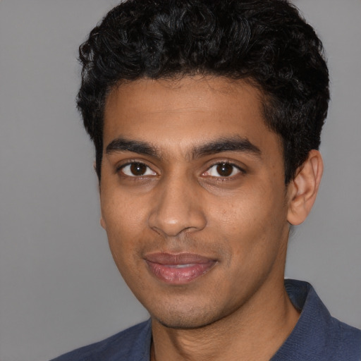 Joyful black young-adult male with short  black hair and brown eyes