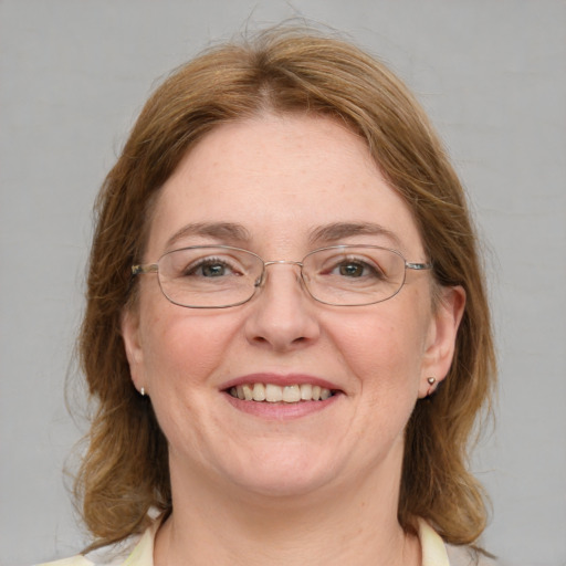 Joyful white adult female with medium  brown hair and blue eyes