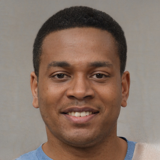 Joyful black young-adult male with short  black hair and brown eyes