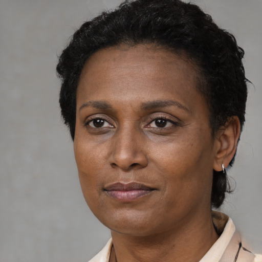 Joyful black adult female with short  brown hair and brown eyes