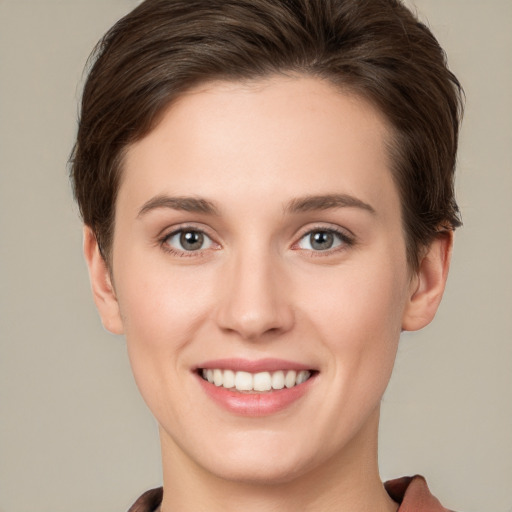 Joyful white young-adult female with short  brown hair and grey eyes