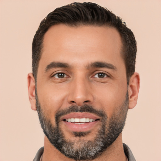 Joyful white young-adult male with short  black hair and brown eyes