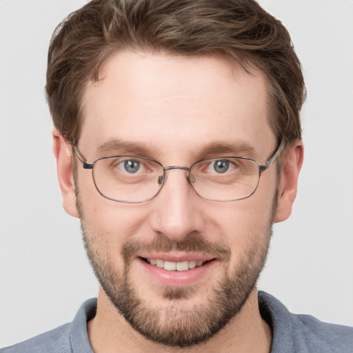 Joyful white young-adult male with short  brown hair and grey eyes