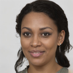 Joyful black young-adult female with long  brown hair and brown eyes