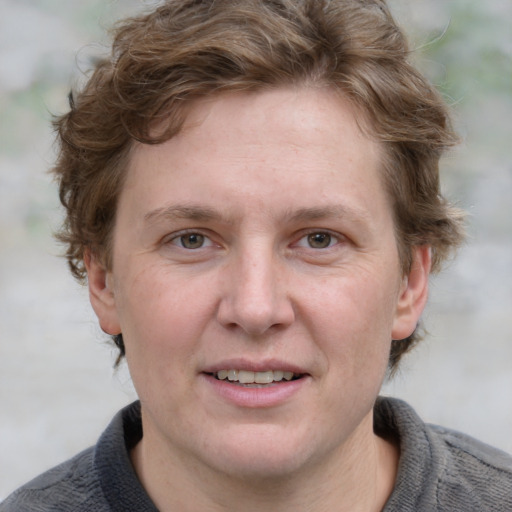 Joyful white adult female with short  brown hair and blue eyes