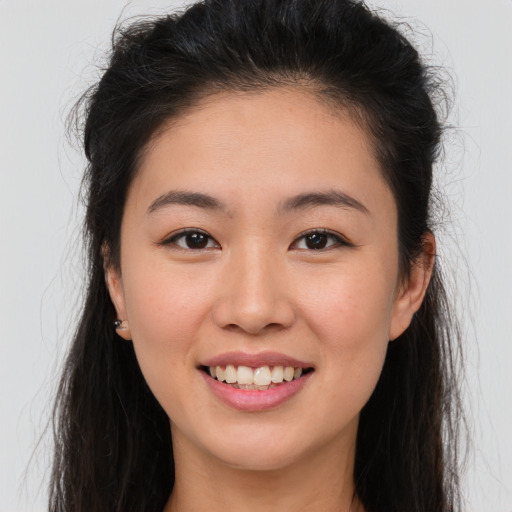 Joyful white young-adult female with long  brown hair and brown eyes