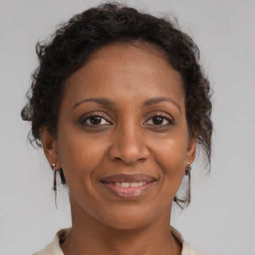 Joyful black adult female with medium  brown hair and brown eyes