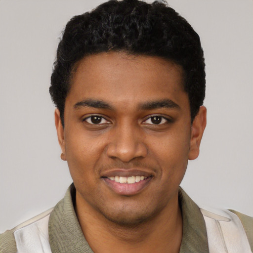 Joyful black young-adult male with short  black hair and brown eyes