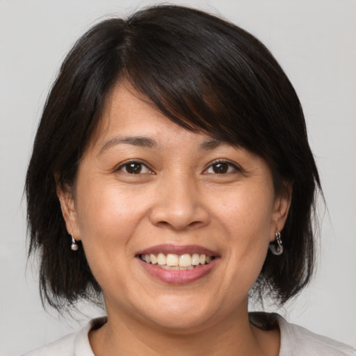 Joyful white adult female with medium  brown hair and brown eyes