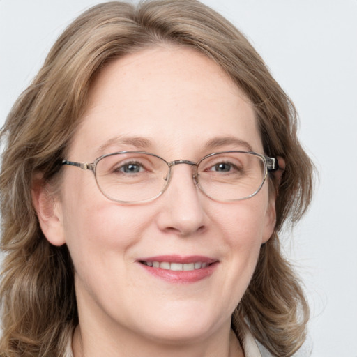 Joyful white adult female with medium  brown hair and blue eyes