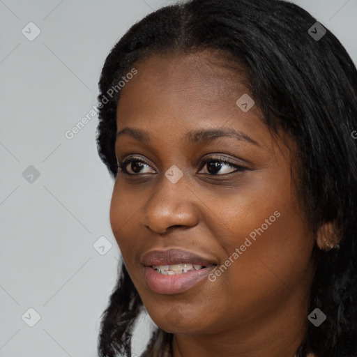 Joyful black young-adult female with long  black hair and brown eyes