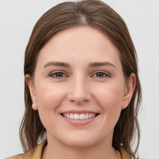 Joyful white young-adult female with medium  brown hair and grey eyes