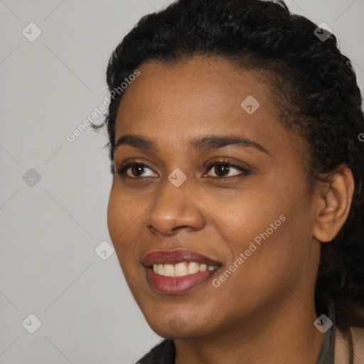 Joyful black young-adult female with short  black hair and brown eyes