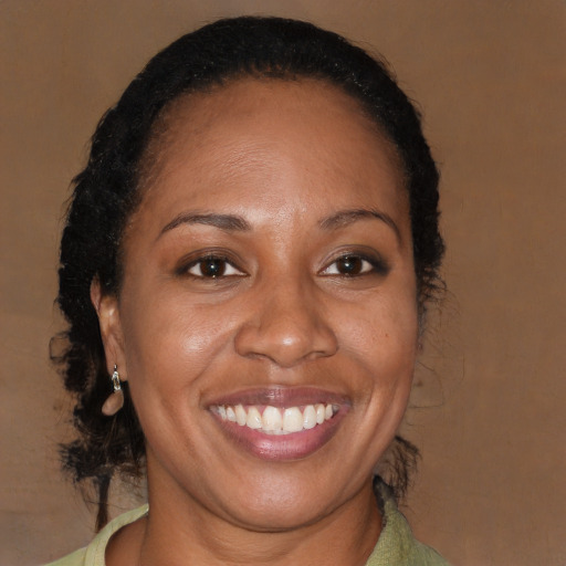 Joyful black adult female with long  brown hair and brown eyes