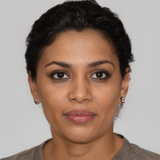 Joyful latino young-adult female with short  black hair and brown eyes