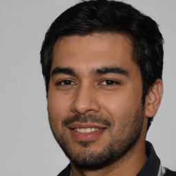 Joyful latino young-adult male with short  black hair and brown eyes