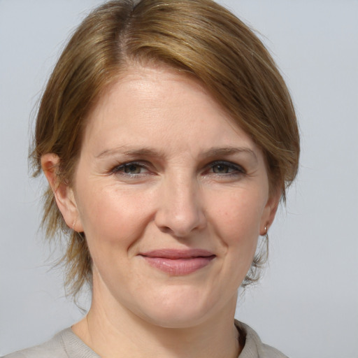 Joyful white adult female with medium  brown hair and blue eyes