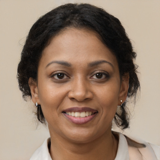 Joyful black adult female with medium  brown hair and brown eyes