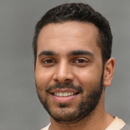 Joyful white young-adult male with short  black hair and brown eyes