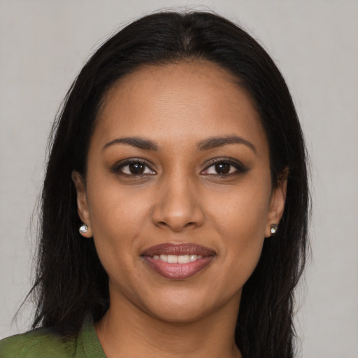 Joyful black young-adult female with long  brown hair and brown eyes