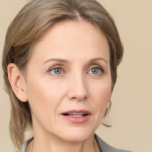 Joyful white adult female with medium  brown hair and grey eyes