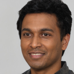 Joyful latino young-adult male with short  black hair and brown eyes