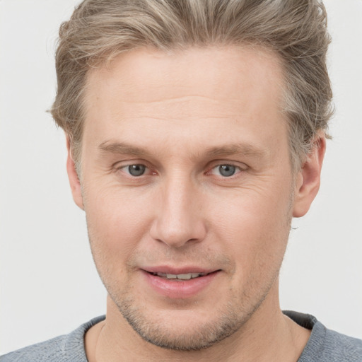 Joyful white young-adult male with short  brown hair and blue eyes