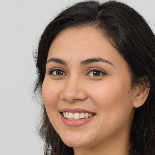 Joyful white young-adult female with long  brown hair and brown eyes