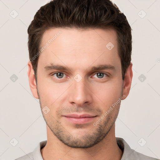 Joyful white young-adult male with short  brown hair and grey eyes