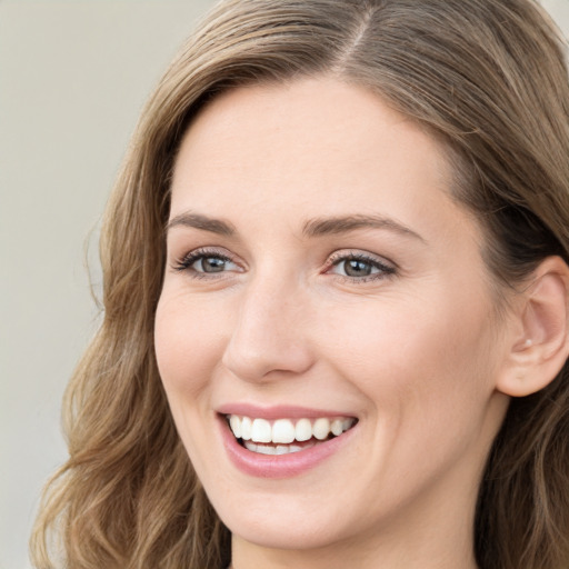 Joyful white young-adult female with long  brown hair and green eyes