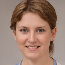 Joyful white young-adult female with medium  brown hair and grey eyes