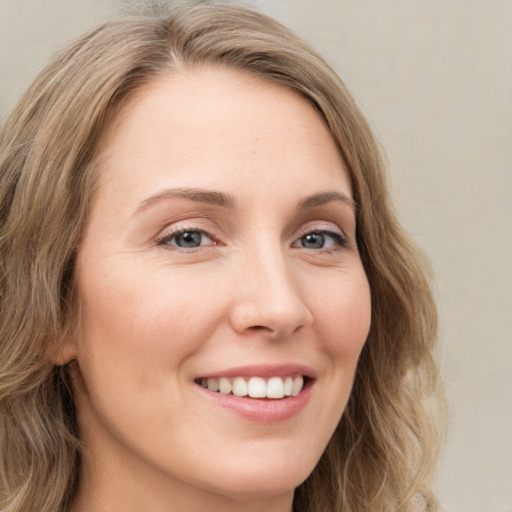 Joyful white young-adult female with long  brown hair and green eyes