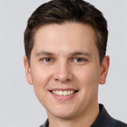 Joyful white young-adult male with short  brown hair and grey eyes