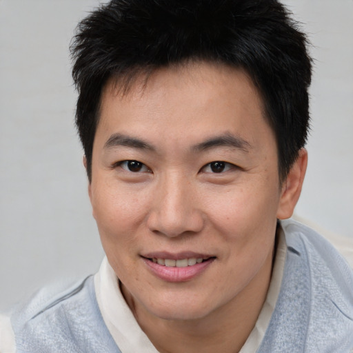 Joyful asian young-adult male with short  brown hair and brown eyes