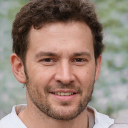 Joyful white adult male with short  brown hair and brown eyes