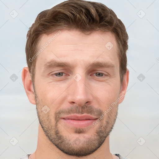 Joyful white young-adult male with short  brown hair and grey eyes