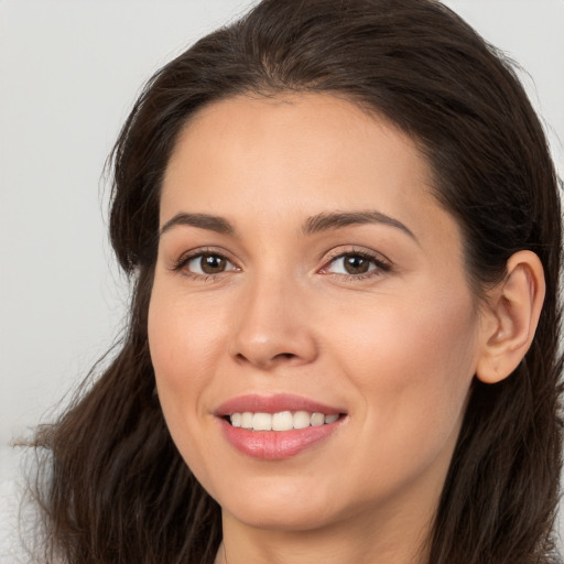 Joyful white young-adult female with long  brown hair and brown eyes