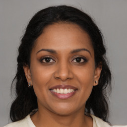 Joyful black young-adult female with long  brown hair and brown eyes