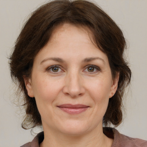 Joyful white adult female with medium  brown hair and grey eyes