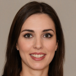 Joyful white young-adult female with long  brown hair and brown eyes